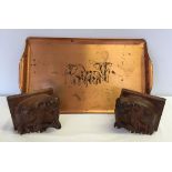 A pair of wooden elephant bookends together with a copper tray decorated with elephants