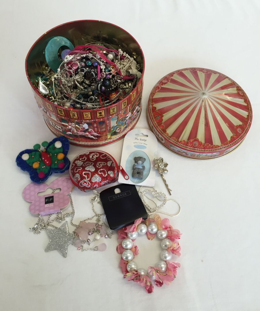 A carousel tin containing a good quantity of childrens jewellery.