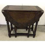 A carved edge, dark oak drop leaf table with drawer to one end. Oval shaped when open. Measures