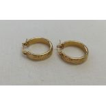 Pair of 9ct gold hoop earrings with engraved detail. Weight approx 1.8g.