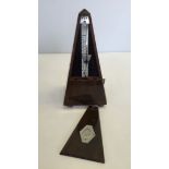 A wooden cased Maelzel Paquet French metronome.