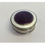 A small round silver pill box with white & purple guilloche design on lid. Hallmarked Birmingham