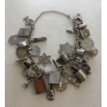 A silver charm bracelet with approx 35 silver charms and coins, total weight approx 76.7g.