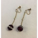 A pair of 9ct gold screw back dangly earrings with seed pearls and glass beads.