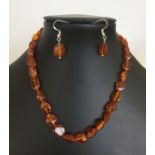 A necklace of irregular size baltic amber beads together with matching earrings. Marked 925.