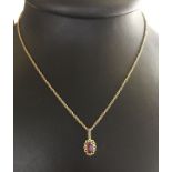 A 14ct gold pendant set with a central oval amethyst on a yellow metal chain