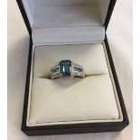 Ladies 9ct gold dress ring set with a large central blue topaz stone with diamond and blue topaz