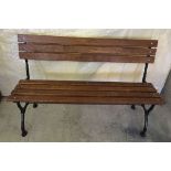 A wooden slated garden bench with cast iron ends.