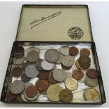 A tin of assorted foreign coins to include USA and a Prince of Wales Model Sovereign coin. Tin