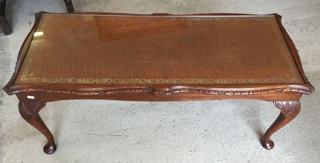 A vintage oak coffee table with brown leather insert top and glass cover