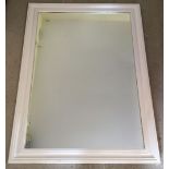 A large white wooden framed mirror.