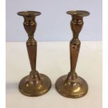 A pair of brass candlesticks approx 21cm high.