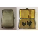 A small cigarette case. Clam shell design with engraved cartouche and gilt interior. The inside