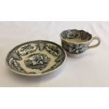 An antique transfer printed tea cup & saucer in black and white depicting scene with gentleman on