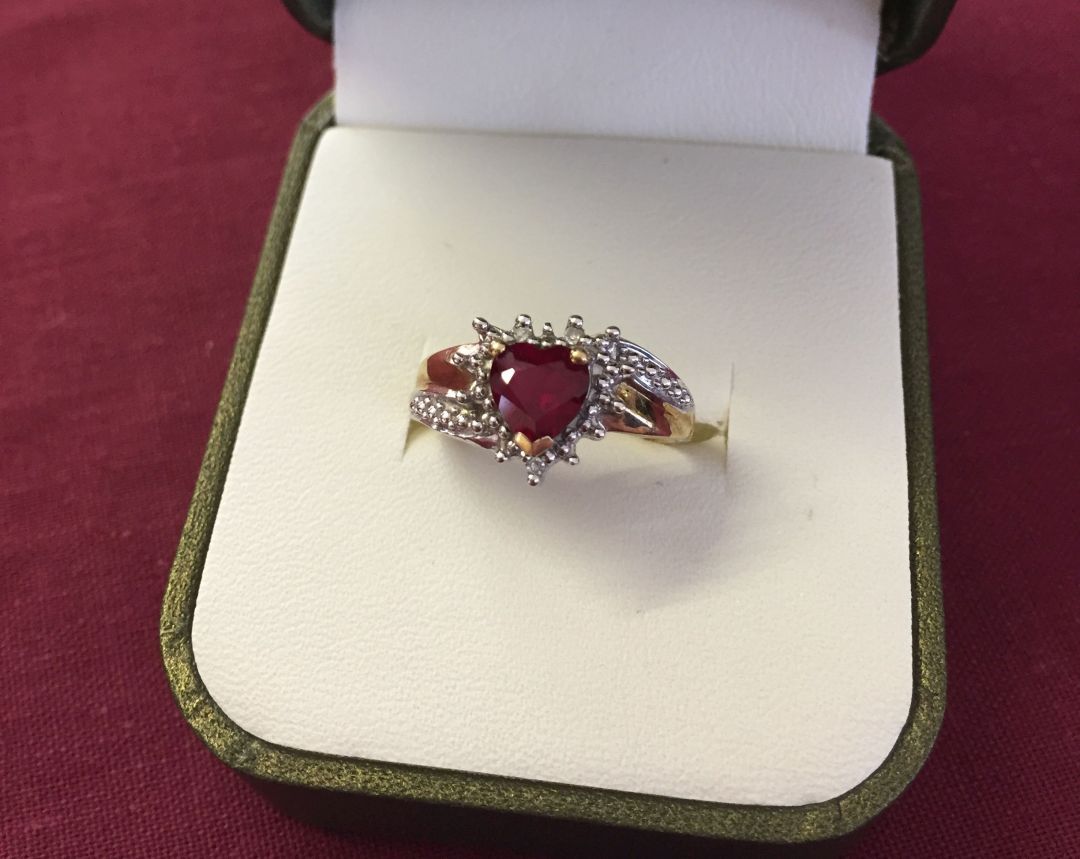 Hallmarked 9ct gold dress ring set with a heart shaped created ruby, surrounded by and mounted