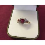 Hallmarked 9ct gold dress ring set with a heart shaped created ruby, surrounded by and mounted