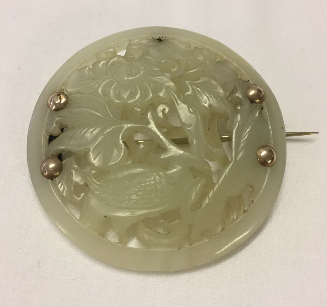 A large round Jade brooch, ornately carved with bird and flower decoration. - Image 2 of 2