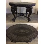 An early 20th century Burmese oak oval carved elephant table. Approx 91 x 65cm