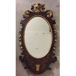 A Regency style oval mirror decorated with phoenix, scroll and flower design.