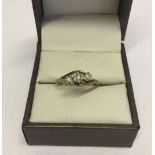 Trilogy ring with cross over shank. Small diamonds in illusion settings, hallmarked 9ct gold. Size