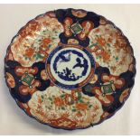 An Imari charger with scalloped edge. Approx 30cm diameter. Hairline crack to rim.