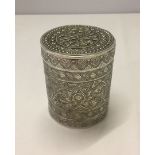 An Indian silver case in cylindrical form with engraving of flowers and plants. 90mm high, 72mm