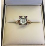 A c1930s 14ct rose gold ring set with baguette cut blue topaz with 4 triangular rubies, one at