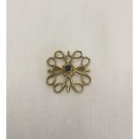 9ct gold open work brooch set with a central sapphire. Measures 2cm square, weight approx 2.3g.