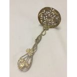 Ornate silver spoon with entwined rope and ivy handle and open fretwork bowl around a branch of