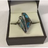 A silver ring set with an oval turquoise stone in a contemporary mount. Size Q, stamped 925.