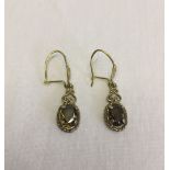 A pair of 9ct gold drop earrings set with smokey quartz.