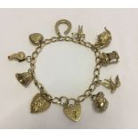 Vintage 9ct gold charm bracelet with 10 charms and heart shaped padlock clasp. Approx weight 18g.