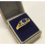 An 18ct gold, sapphire and diamond ring. Size O1/2 (one small diamond missing).