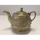 A silver indian teapot with hunting scene engraving to the entire pot and lid. 110mm high, 100mm