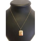 A 9ct gold front and back rectangular locket on a 9ct gold 26" chain.