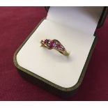 Hallmarked 9ct gold dress ring set with 3 rubies and 6 small diamonds. Size M, total weight approx