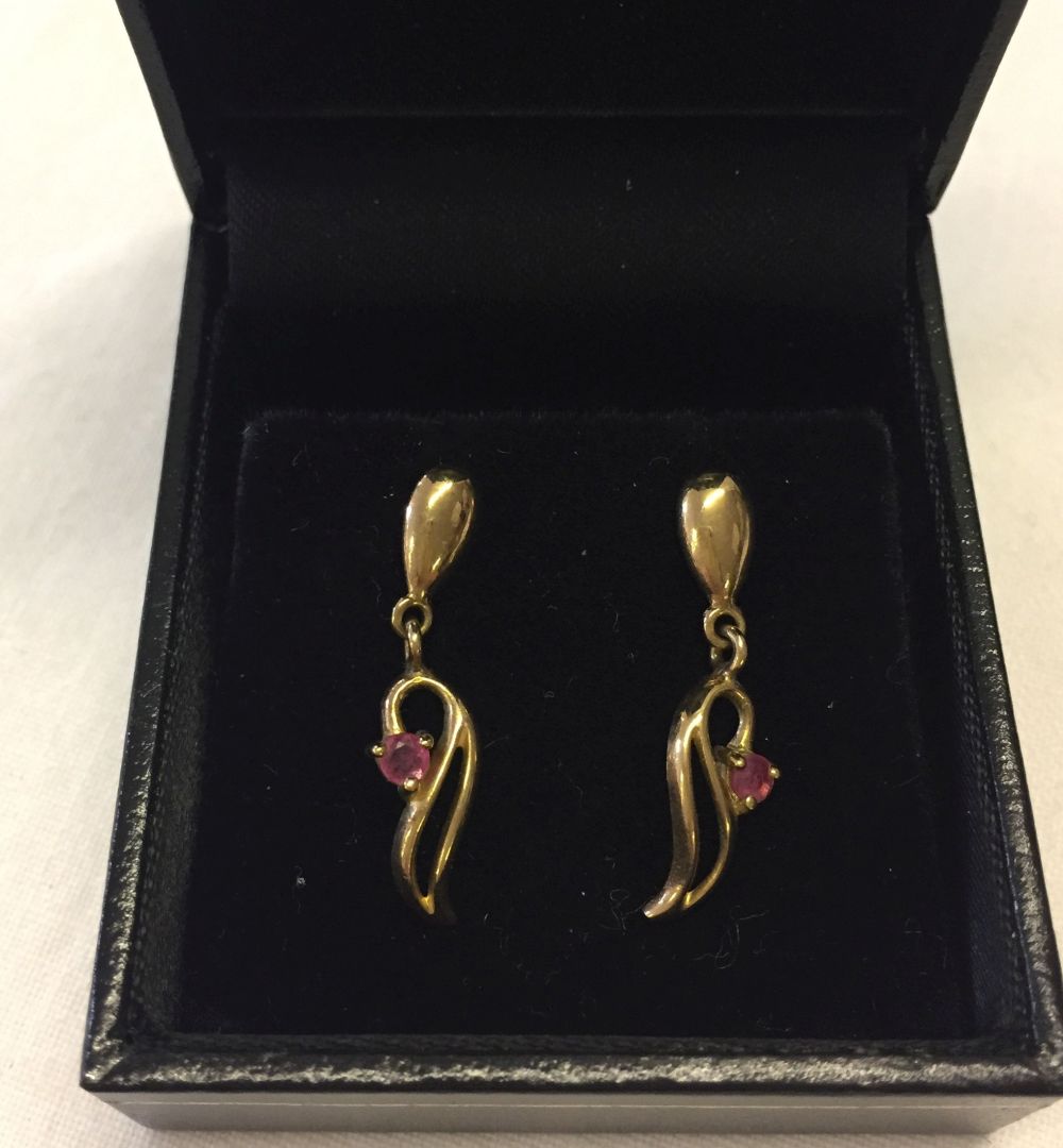 A pair of 9ct gold pendant earrings set with rubies.