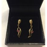 A pair of 9ct gold pendant earrings set with rubies.