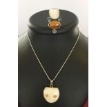 A carved cat face pendant set in 925 silver on a rope chain together with pearl cat face ring set