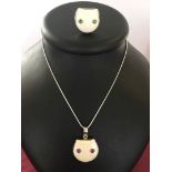 A carved cat face pendant with amethyst eyes set in 925 silver on a rope chain together with a