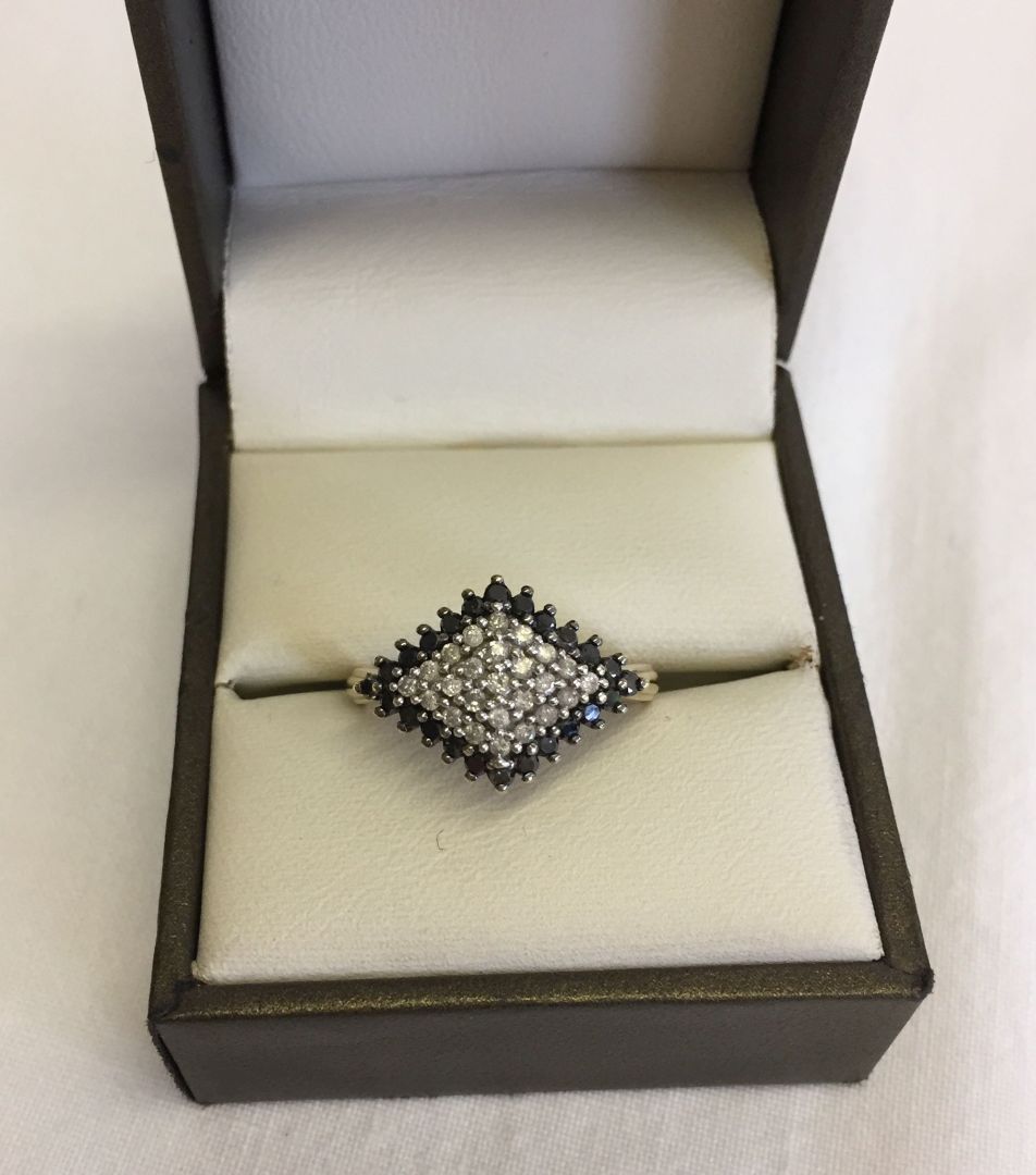 Ladies 9ct gold dress ring set with black and white diamonds in a diamond shaped mount. Size P.