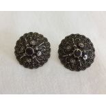 A large pair of ornately decorated 925 silver earrings set with amethysts.