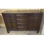 An Ercol dark wood sideboard with 4 central drawers.