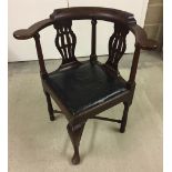 A dark oak, lyre back corner chair with black leather seat.