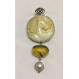 A carved horse head pendant/brooch set with a yellow opal cabouchon & a pearl in 925 silver.