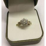 A 9ct gold diamond cluster ring with diamond set shoulders. Size J. Total weight 2.5g.