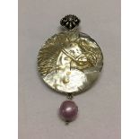 A mother of pearl carved horse head pendant/brooch set in 925 silver with a pink mabe pearl.