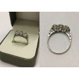 A Past, Present and Future diamond ring set in platinum. Small diamond set to each shoulder and