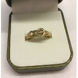A 9ct gold buckle ring with decoration to top. Size O1/2 total weight 1.9g.
