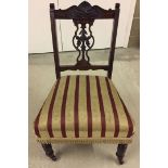 A red and cream upholstered nursing chair with caster feet.